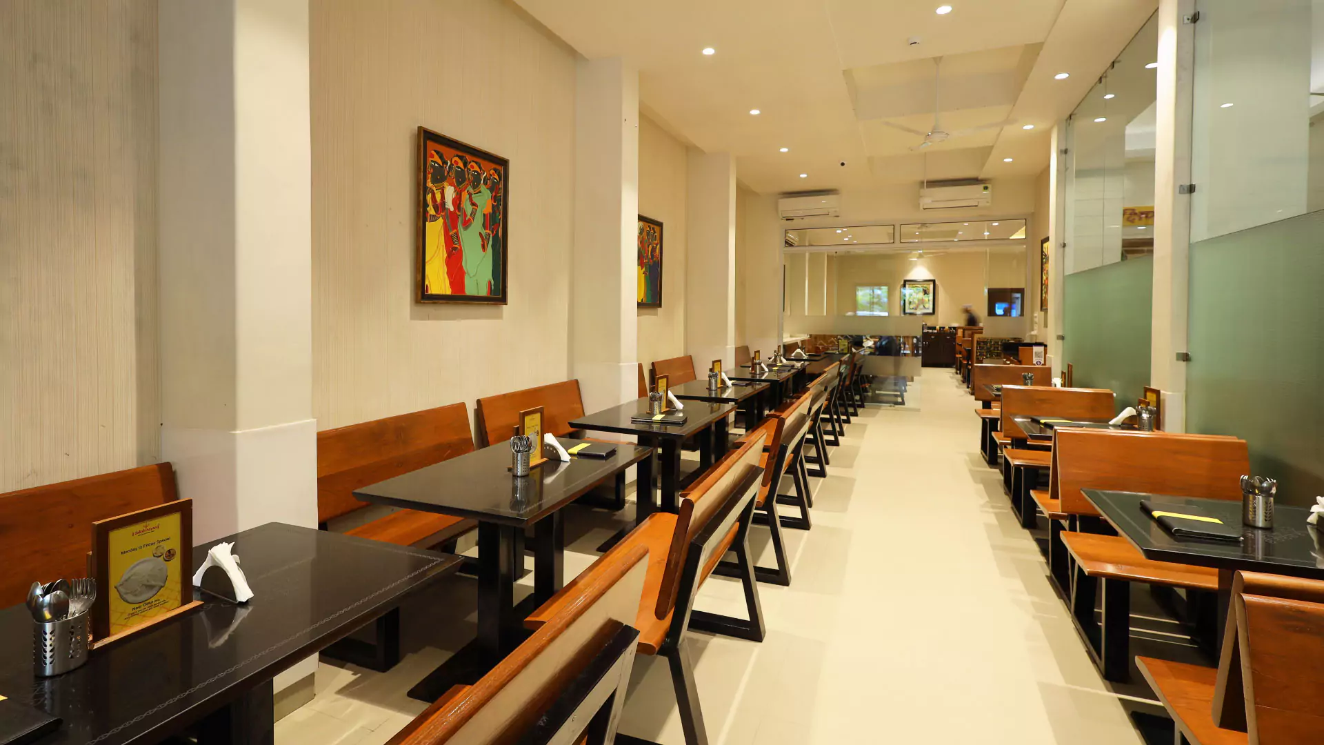 Restaurant dining hall and wooden booth seating by Anand Premises